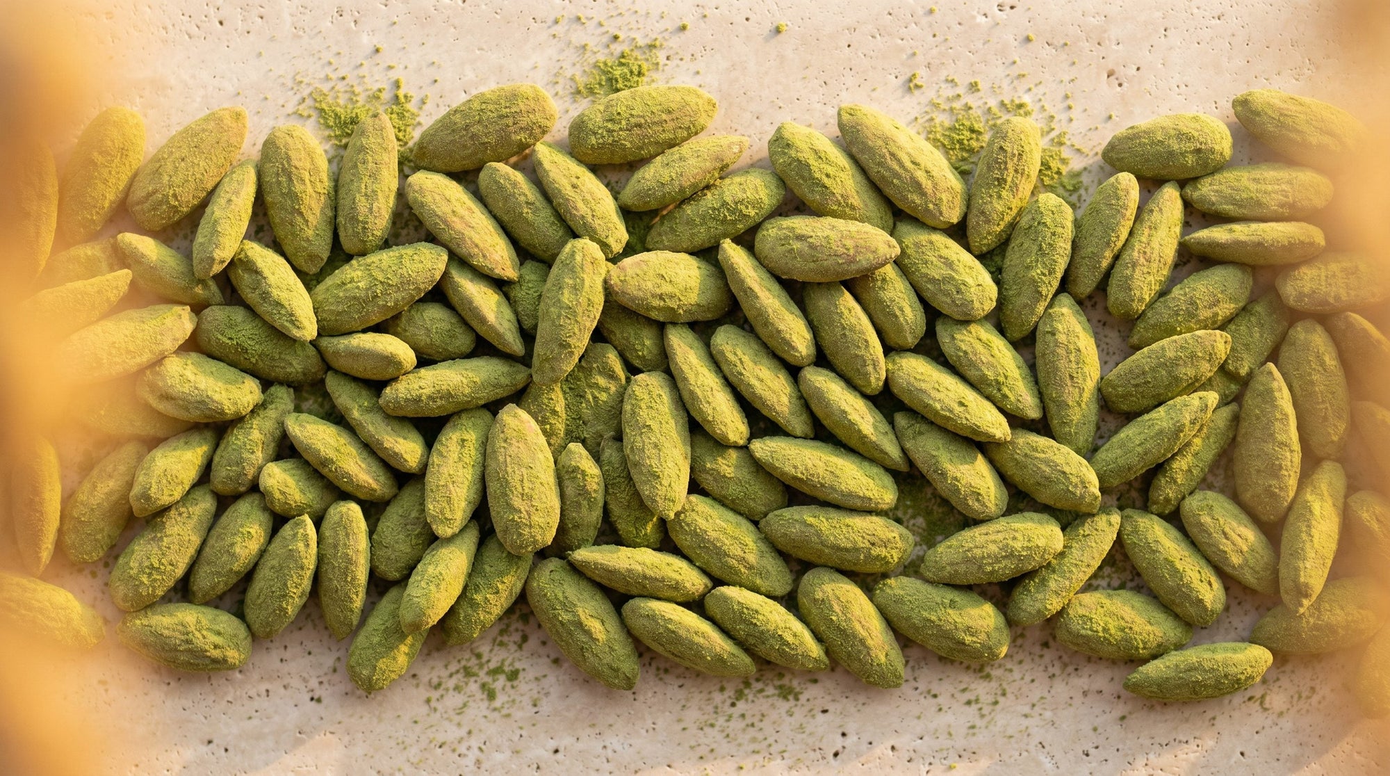 Amande Wasabi, bande texture amandes longues effilées vertes mates, rhizome et feuille de wasabi sur pierre claire