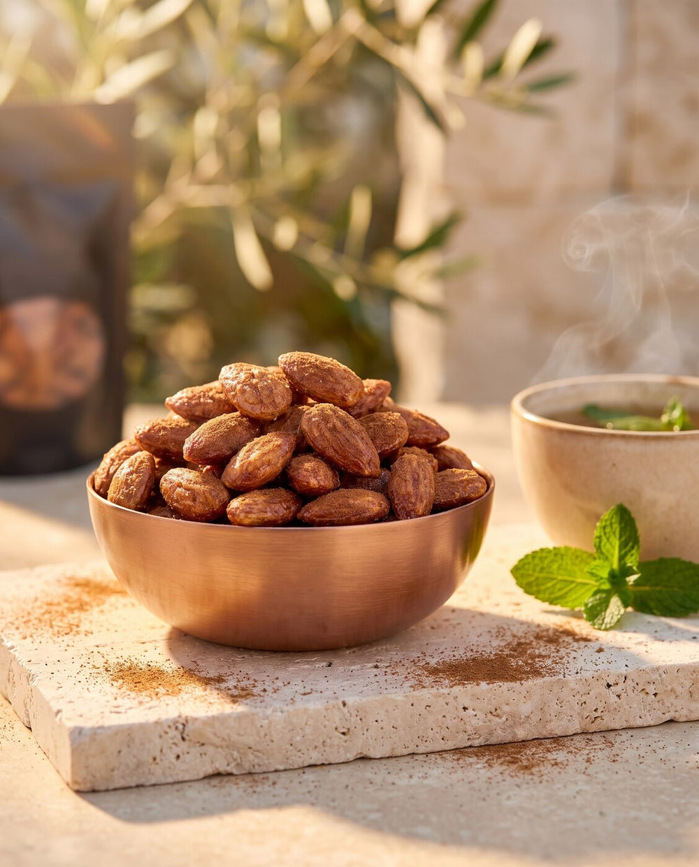 Amande Cannelle, moment thé à la menthe, bol de cuivre rempli d'amandes à la cannelle sur pierre claire