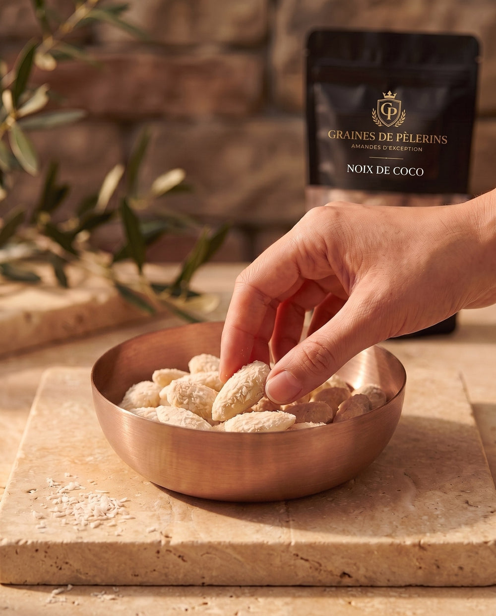 Amande Noix de Coco, moment gourmand, bol de cuivre rempli d'amandes à la noix de coco sur pierre claire