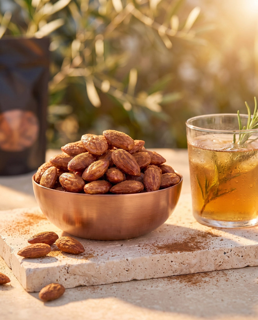 Amande Salées Fumées, moment infusion glacée au romarin, bol de cuivre rempli d'amandes fumées sur pierre claire