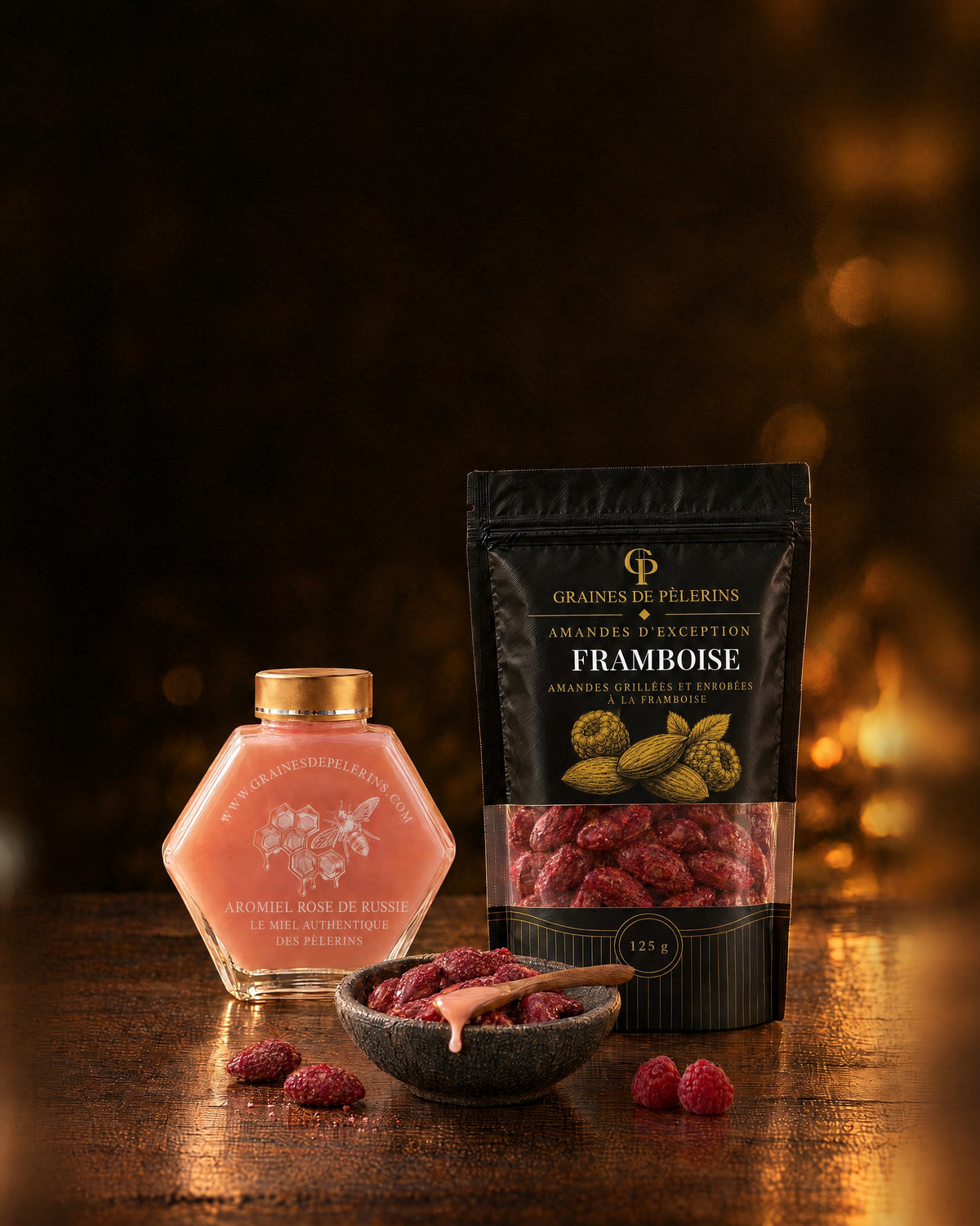 Ein Glas Aromiel Rose und ein Beutel Himbeermandeln, davor ein Schälchen Mandeln und ein paar Himbeeren.