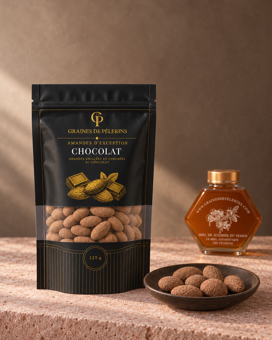 Sachet et coupelle d’amandes Chocolat sur une pierre rose, avec un Miel de Jujubier en arrière-plan.