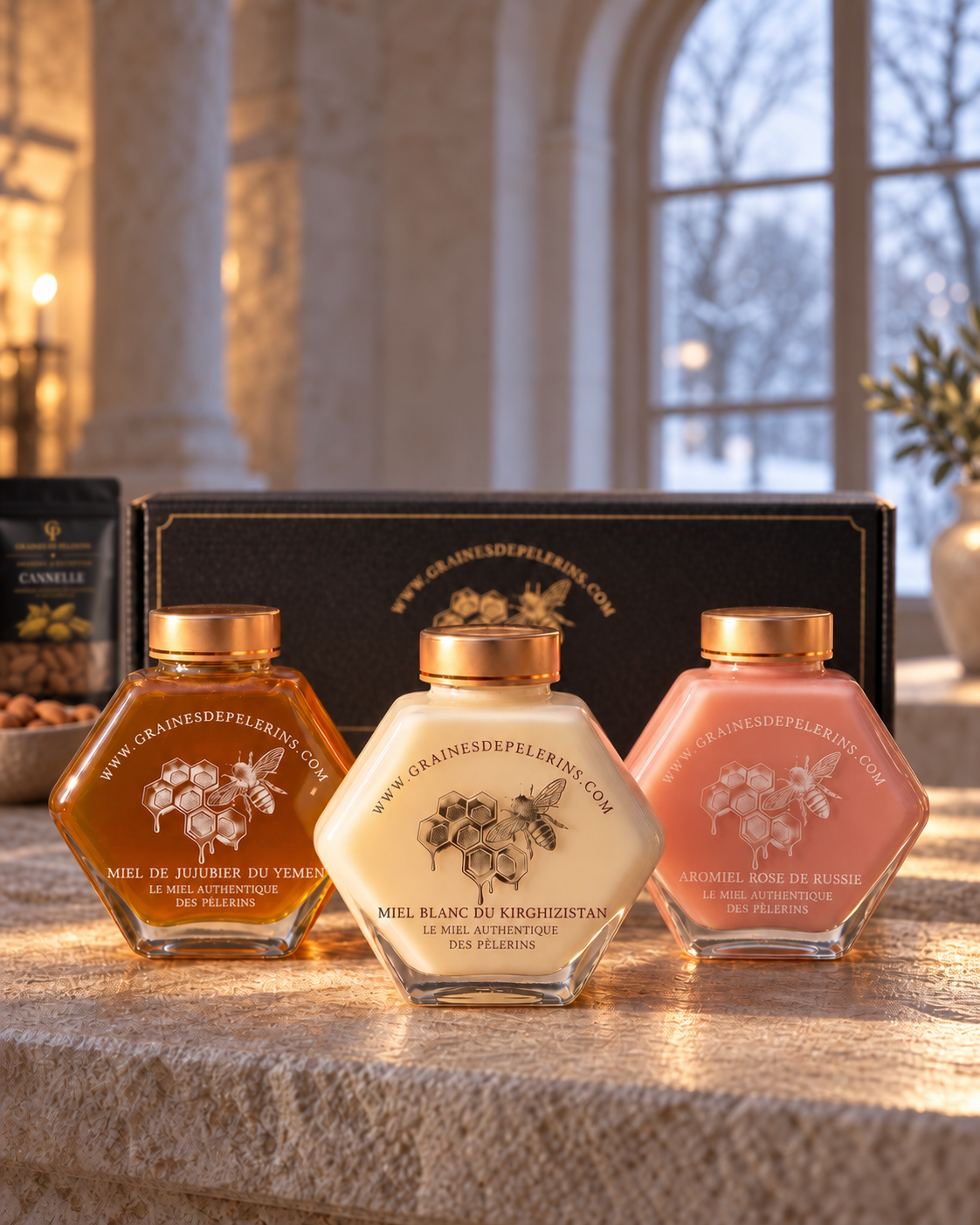 Coffret Prestige : Jujubier, Miel Blanc et Aromiel Rose, arcade de pierre hivernale, avec un coffret noir et or.