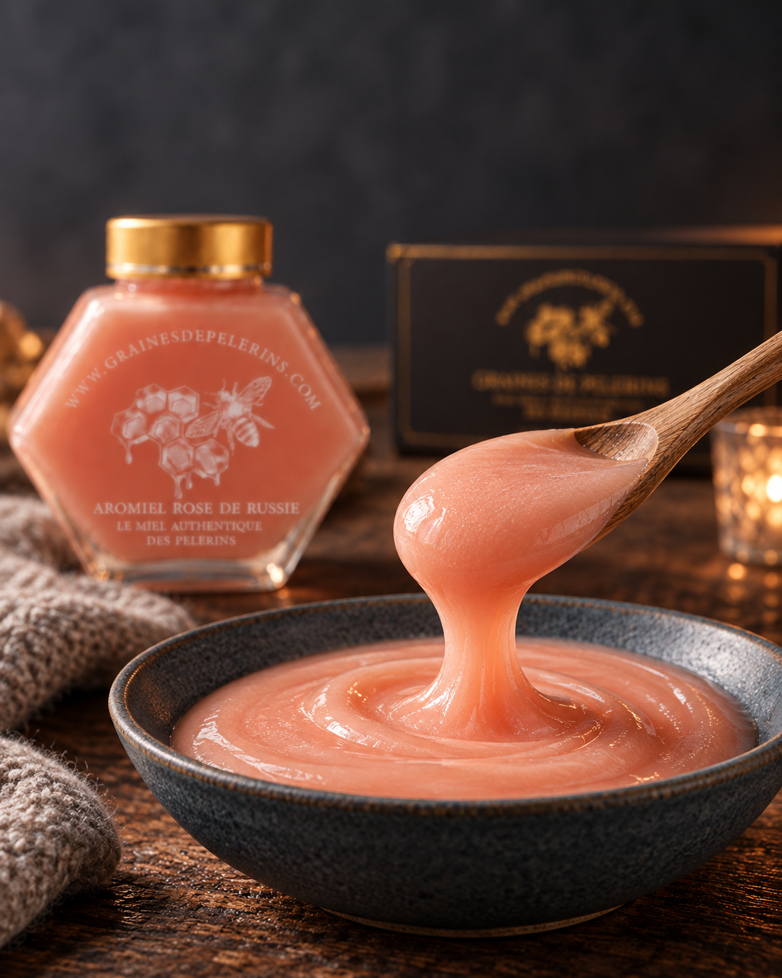 Aromiel Rose cremoso en una cuchara de madera sobre un cuenco, con su frasco y un estuche detrás.