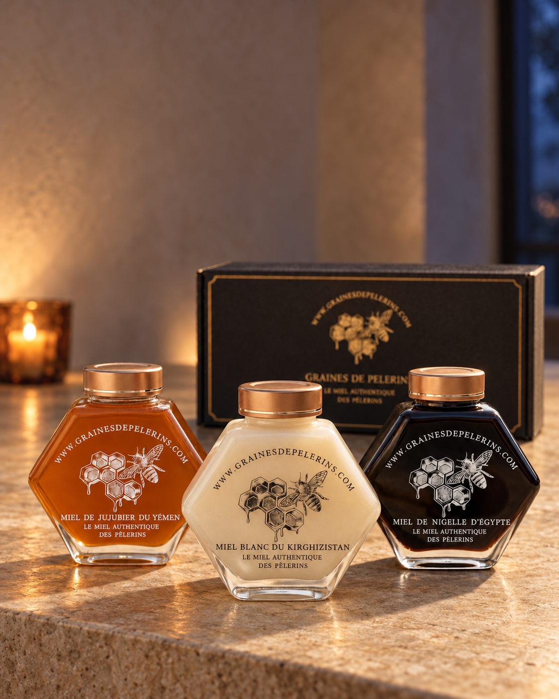 Coffret Vitalité Graines de Pèlerins : trois pots de 250 g, Miel de Jujubier du Yémen, Miel Blanc du Kirghizistan et Miel de Nigelle d’Égypte, devant leur écrin noir et or