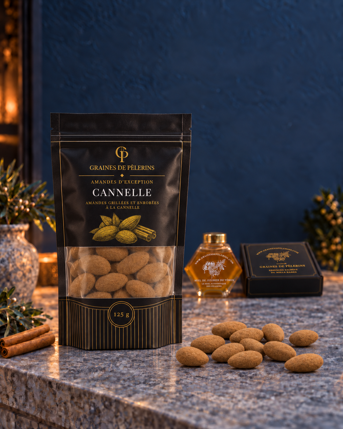 Beutel mit Zimtmandeln auf einer blauen Konsole, mit Geschenkbox und Honigglas im Hintergrund.