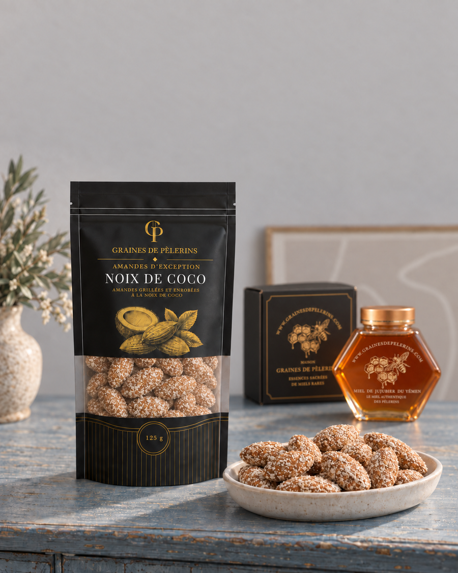 Beutel und Schale mit Kokosmandeln auf einer blauen Konsole, mit Jujubier-Honig und seiner Geschenkbox im Hintergrund.