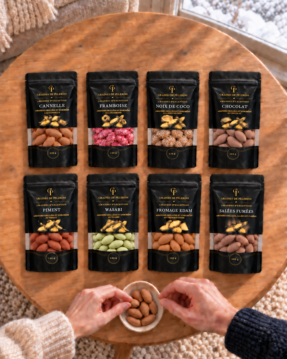 Les huit sachets sur une table en bois vue de dessus, avec une assiette d’amandes à partager.