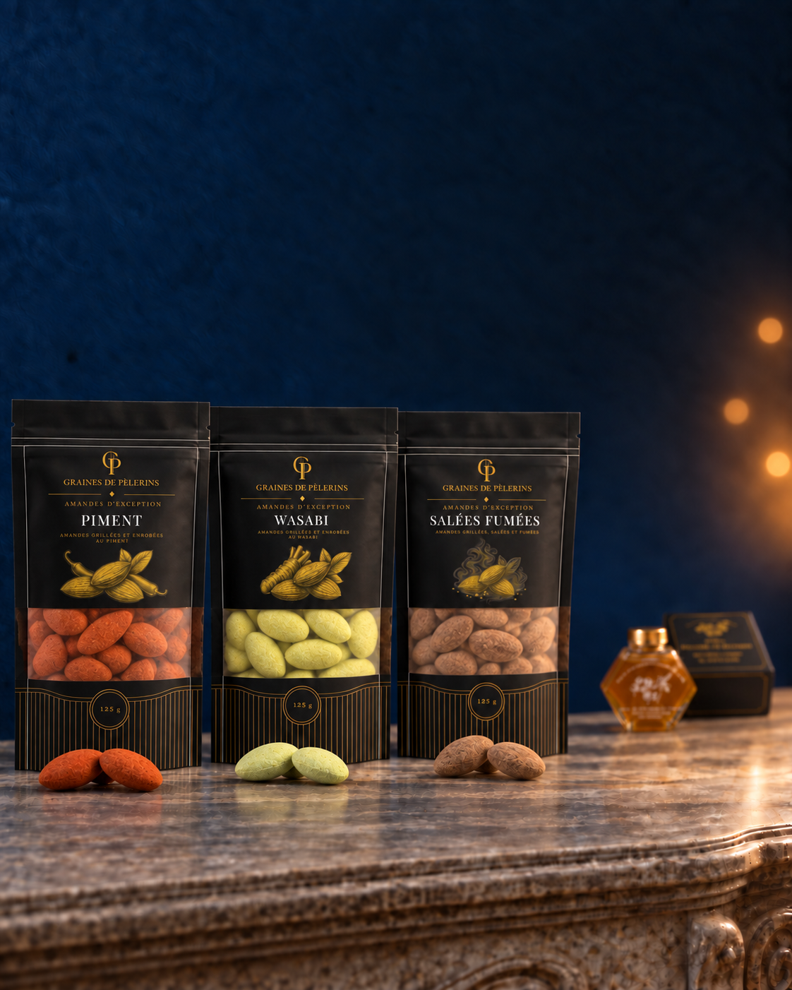 Les trois sachets Piment, Wasabi vert et Salées Fumées avec leurs amandes ; un miel de Jujubier et son écrin restent en arrière-plan.