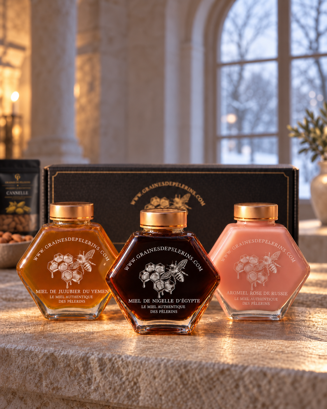 Coffret Les Trois Routes devant l’écrin noir et or, dans la lumière d’hiver d’une fenêtre