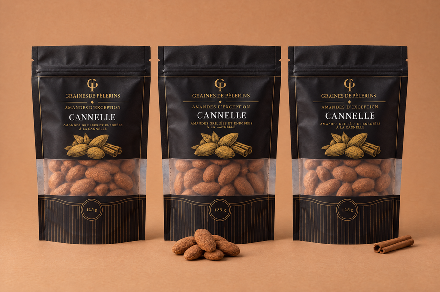 Rituel Amandes d’Exception Cannelle : 3 sachets noir et or de 125 g, amandes à la cannelle et bâtons de cannelle sur fond cannelle